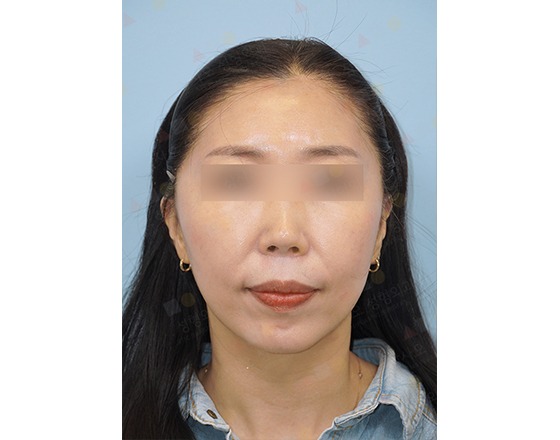 Woman with long hair, calm expression, blue background.