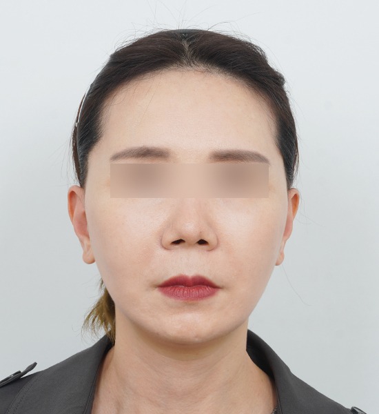 Woman with neutral expression, blurred eyes.